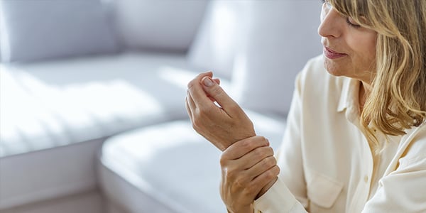 Femme assise qui tient son poignet