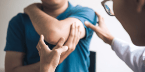 homme avec thérapeute qui examine le coude