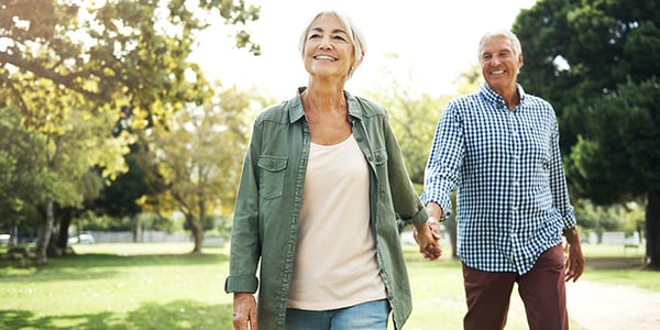 Femme et homme qui marchent dans un parc en se tenant la main