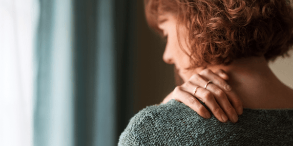 Femme qui tient son épaule