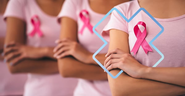 Gros plan sur un groupe de femmes portant des t-shirts roses et arborant un ruban rose sur leur poitrine, symbole de la lutte contre le cancer du sein. Elles croisent les bras en signe de solidarité et de soutien.