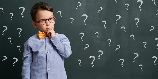 Enfant qui tient son menton avec points d'interrogation en arrière-plan