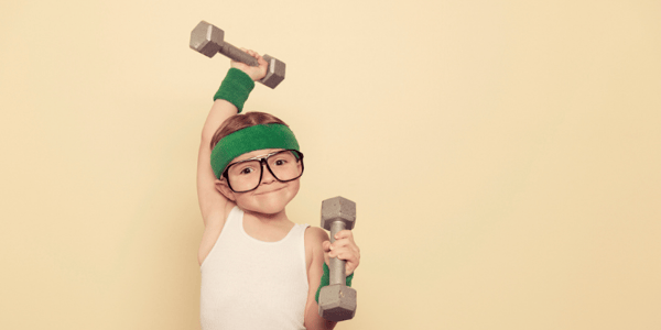 Enfant en vêtements de sport qui soulève des haltères